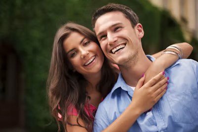 A smiling couple hugging outdoors